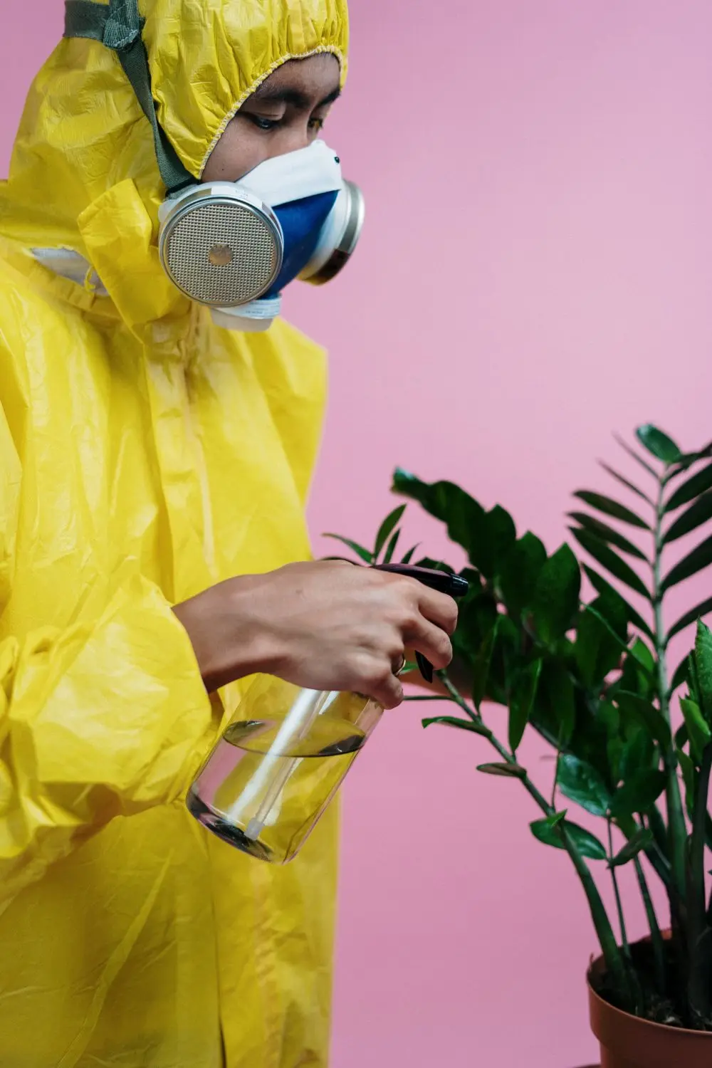 A technician in a yellow suit spraying.