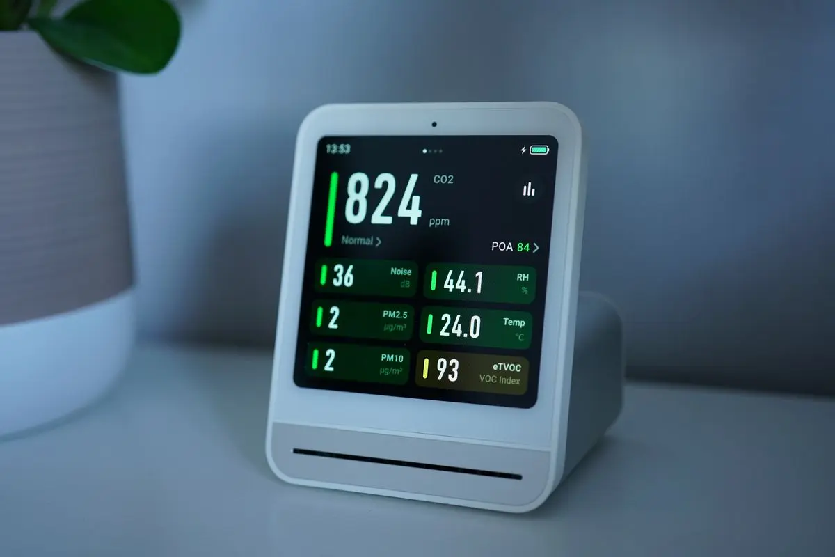 A digital air-quality monitor showing a live reading.